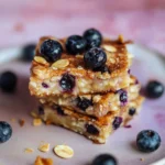 Top view of a blueberry cottage cheese breakfast bake sliced into squares on parchment